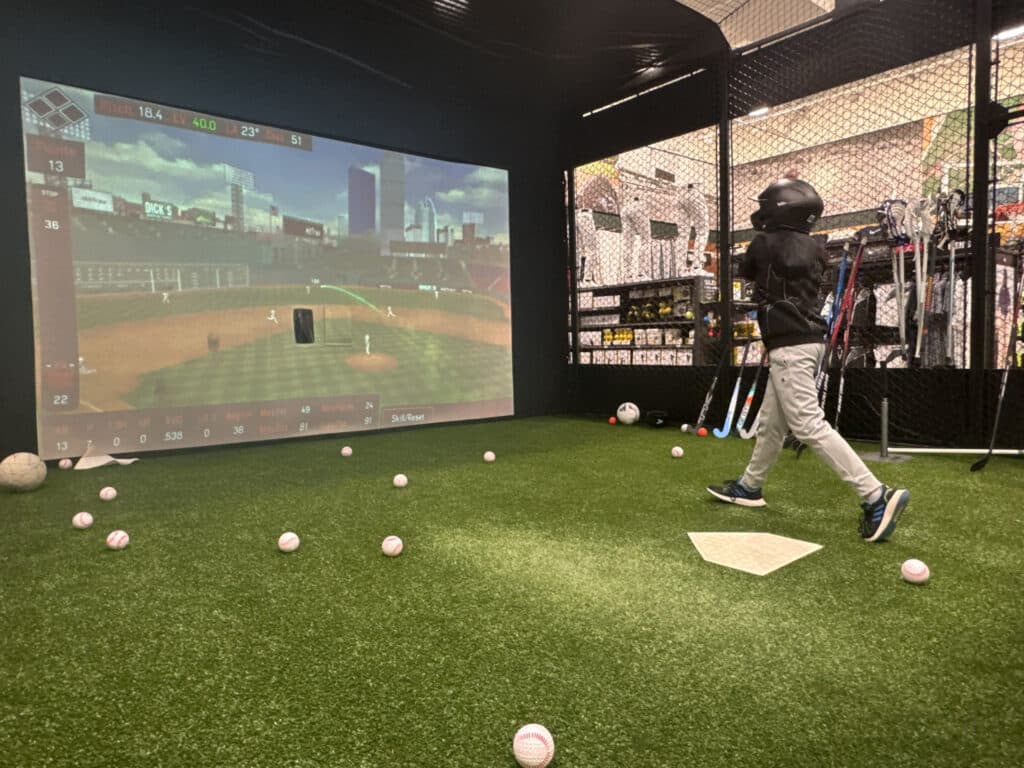 A customer of a retail store hitting in a HitTrax Suite. 